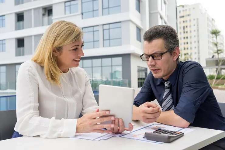 Professional estate tax consultant advising client on inheritance tax planning with documents and tablet