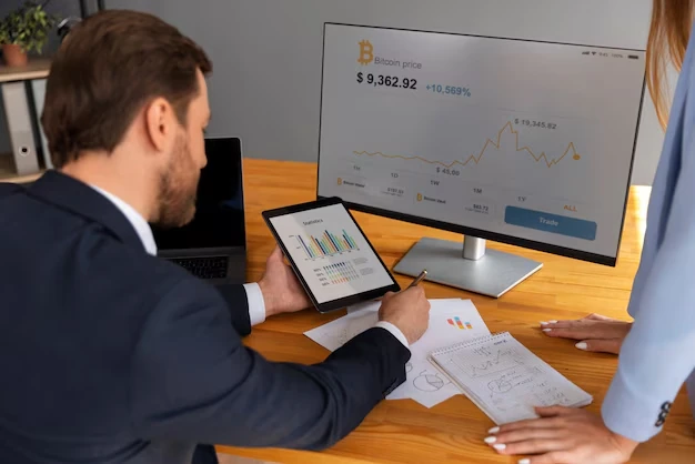 sole trader reviewing financial reports with cryptocurrency data on screen