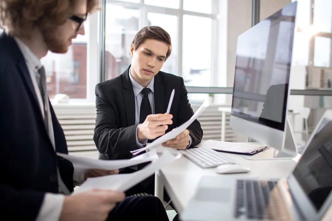 UK regulatory compliance audit team reviewing legal documents and compliance reports in modern office meeting