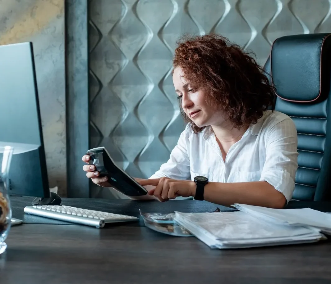 Professional woman using tablet for self-employed accounting services in modern office environment